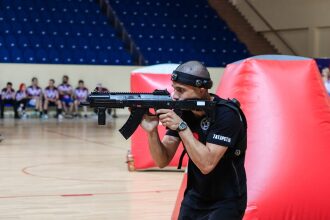 Боец LASERWAR с автоматом нацеливается в игре.
